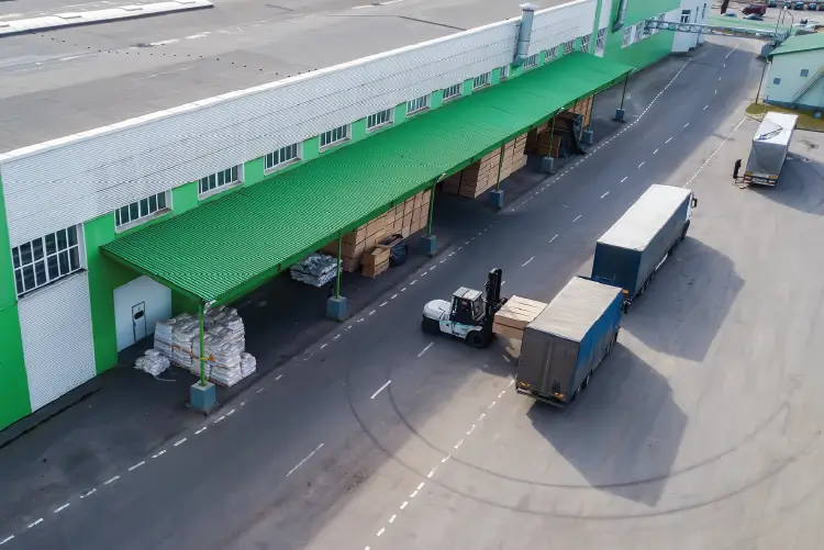A busy warehouse with trucks and a forklift, showcasing the efficient freight handling involved in transport between Melbourne and Sydney.