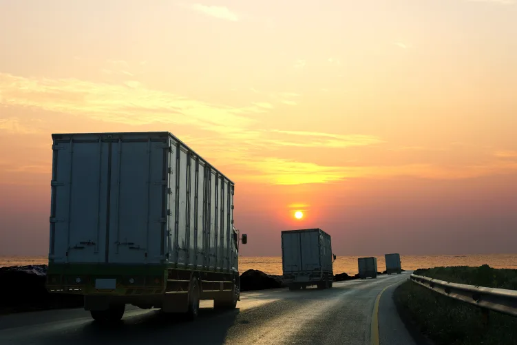 Freight truck driving during sunset, representing long-distance interstate transport from Melbourne to Brisbane.