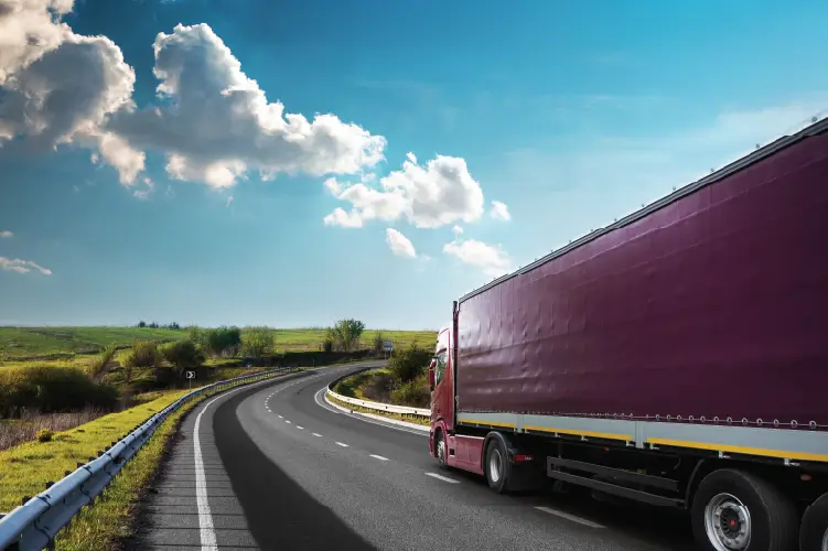 A freight truck traveling on a scenic highway, representing interstate freight transport from Melbourne to Adelaide.