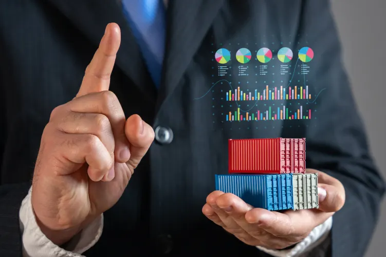 A close-up of a person in a suit pointing a finger, with digital financial graphs and miniature containers overlaid on their hand, representing data and logistics solutions.