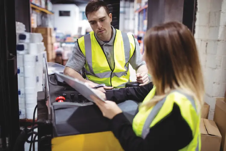 A courier prepares for dispatch in a busy warehouse, ensuring swift delivery between Melbourne and Sydney.