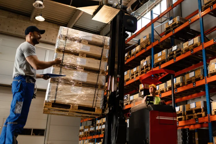 Warehouse staff using a forklift for freight loading and unloading, highlighting logistics operations in action.