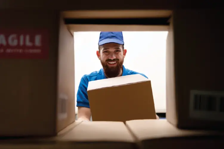 A delivery worker in handling a package, symbolizing fast and reliable Adelaide to Melbourne freight services.